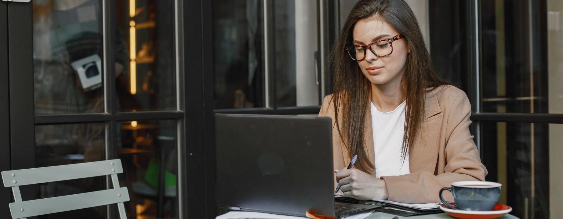 a person sitting at a table with a laptop