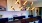 Liberty Duet Apartments, Salt Lake City, Utah, Rooftop Lounge, kitchen area, microwave, sink, cooktop, long table for group seating, dishwasher, overhead decorative gold lights. 