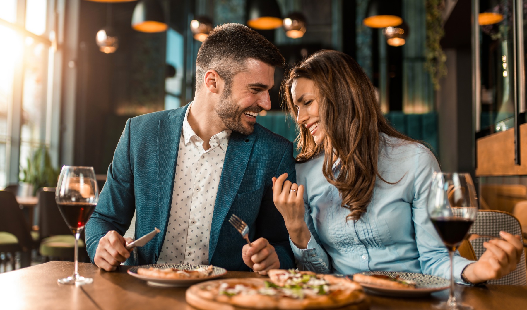 couple dining with pizza at restaurant